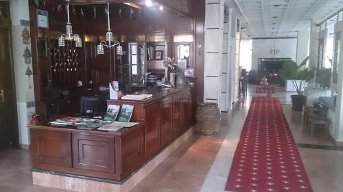 ドラマにあるHotel Villa Taskoのカウンターと赤いカーペットが備わる広い客室です。