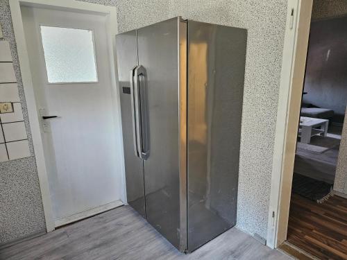 a stainless steel refrigerator in the corner of a room at Gästewohnung in der Nähe des Ferienparks Plötzky in Plötzky