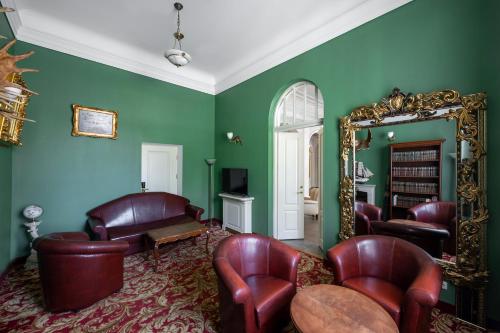 a living room with leather chairs and a mirror at Europa Royale Druskininkai in Druskininkai