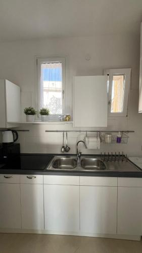 a kitchen with white cabinets and a sink at Casa Colò in Naples