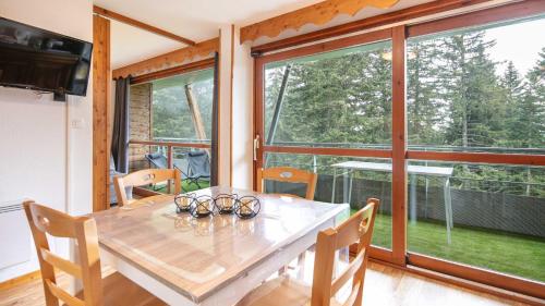- une salle à manger avec une table et des verres dans l'établissement V DU BACHAT - Asters D22 - Appt 5 pers, à Chamrousse