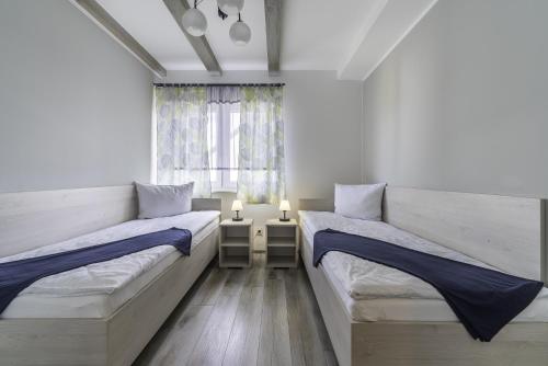 a bedroom with two beds and a window at FRAJDA Domki - Apartamenty 6-osobowe - salon i dwie sypialnie oraz Studia 4-osobowe - pokój z aneksem kuchennym in Rewal