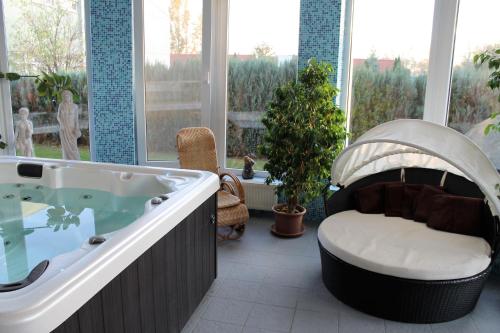 a large bathroom with a tub in a room with windows at Penzión Hellene in Piešťany