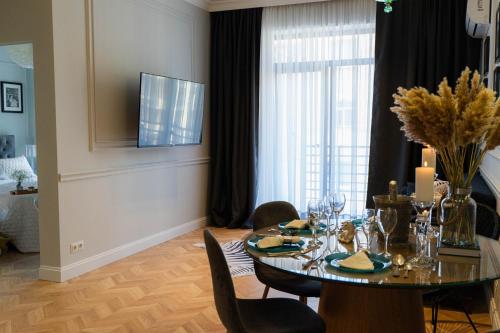 a dining room with a table and chairs and a television at Easy Rest in Tbilisi City