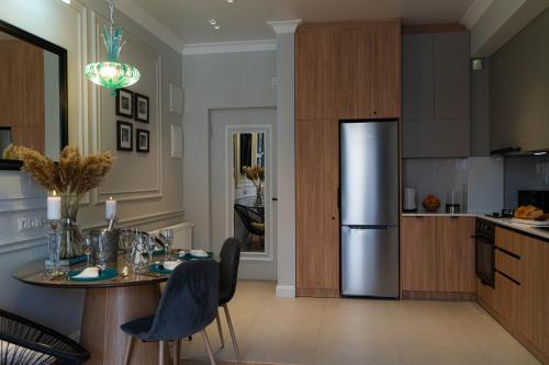 a kitchen with a table and a stainless steel refrigerator at Easy Rest in Tbilisi City