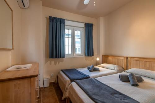 ein Schlafzimmer mit zwei Betten und einem Fenster in der Unterkunft Marina II by Ĥ - Marina Isla Canela PMHII27P65 in Punta del moral
