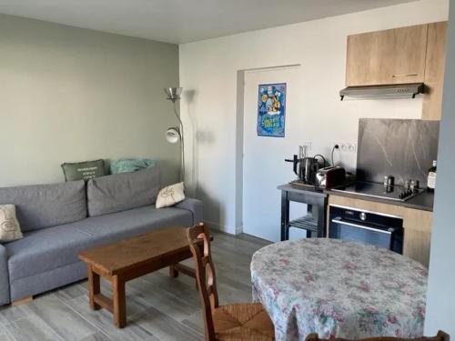 un salon avec un canapé et une table dans l'établissement Appartement charmant aux Sables-d'Olonne avec terrasse., à Les Sables-dʼOlonne