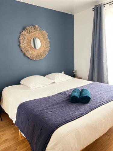 une chambre avec un grand lit avec un miroir au mur dans l'établissement Le Rabelais, superbe appartement en duplex, proche forteresse et monument historique, à Chinon