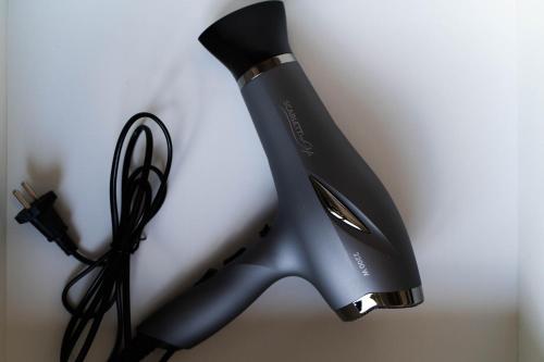 a black hair dryer next to a pair of scissors at Easy Rest in Tbilisi City
