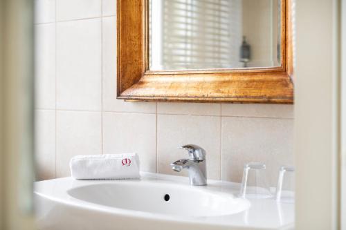 a bathroom sink with a mirror and a towel at Europa Royale Druskininkai in Druskininkai