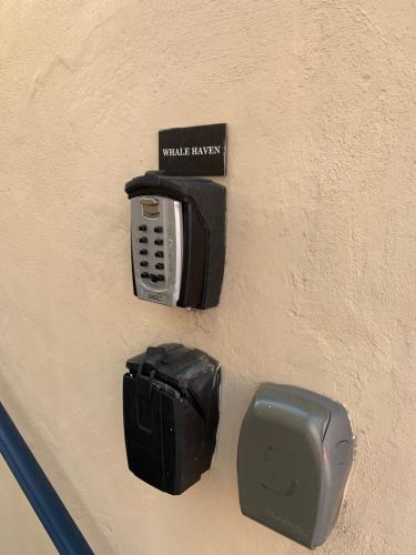 a wall with a phone and a paper towel dispenser at Whalehaven in Kalk Bay