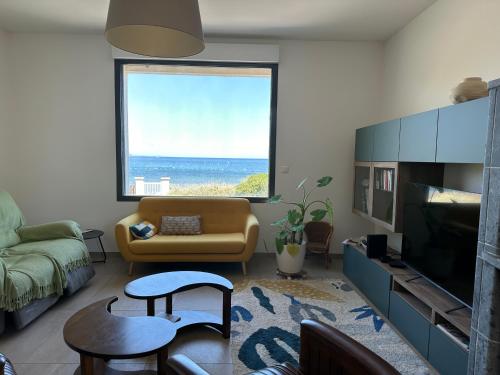 un salon avec un canapé et une grande fenêtre dans l'établissement Pleine mer, à La Seyne-sur-Mer