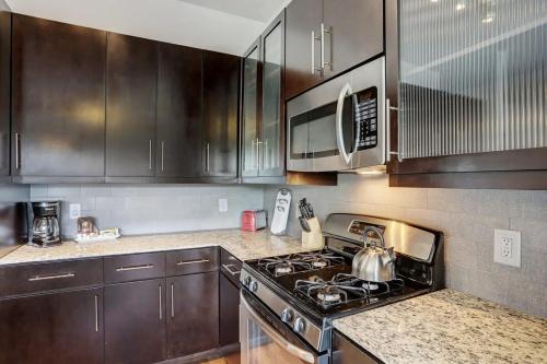a kitchen with wooden cabinets and a stove top oven at Jade At Millennium - 3 Bed Apt in Houston in Houston