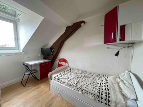 - une chambre avec un lit, un bureau et un escalier dans l'établissement L'Essentiel, à Dijon