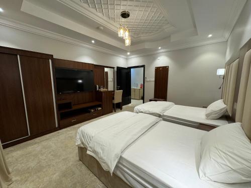 アル・ウラーにあるRosaBella Hotel - شقق روزابيلا الفندقيةのベッド2台と薄型テレビ付きのホテルの部屋
