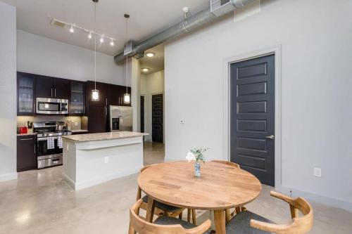 a kitchen with a wooden table and some chairs at Peony At Millennium - Elegant 2 Bed Apt in Houston in Houston