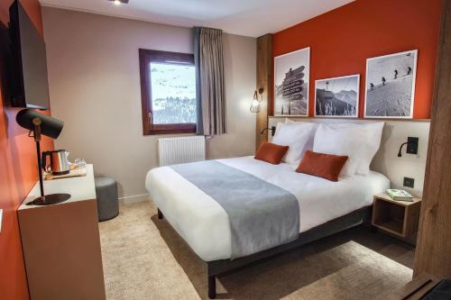 a hotel room with a large bed and a window at Belambra Clubs Flaine Panorama in Flaine