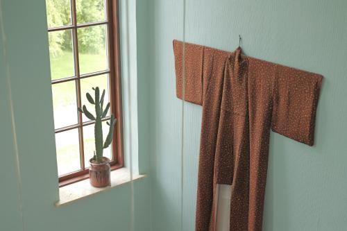 a cross hanging on a wall next to a window at Huset i Hejls in Hejls