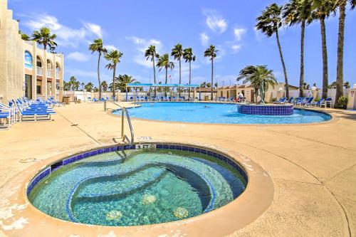 a swimming pool at a resort with palm trees at Canalfront Port Isabel Cottage 5 Mi to Beach! in Port Isabel