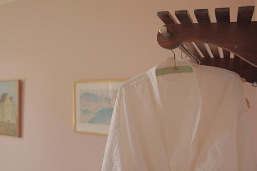 a white dress hanging on a wooden chair at Huset i Hejls in Hejls