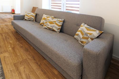 a couch with pillows on it in a living room at APARTMÁNY Sninský dvor in Snina