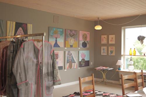 a room with a rack of clothes and pictures on the wall at Huset i Hejls in Hejls