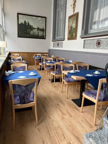 a dining room with blue tables and chairs at Logierhaus Extra in Norderney