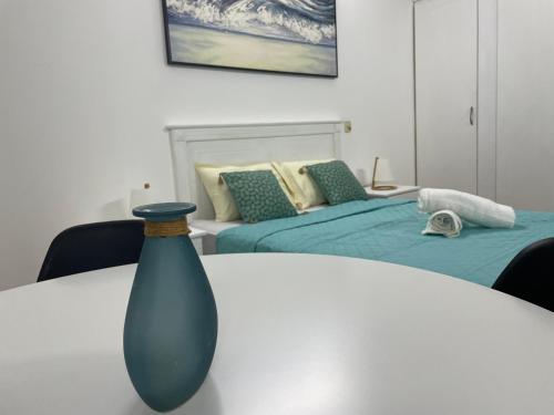 a blue vase sitting on a table next to two beds at Sam & Chlo Studio & Appartment - Grand Baie - Mauritius in Grand Baie