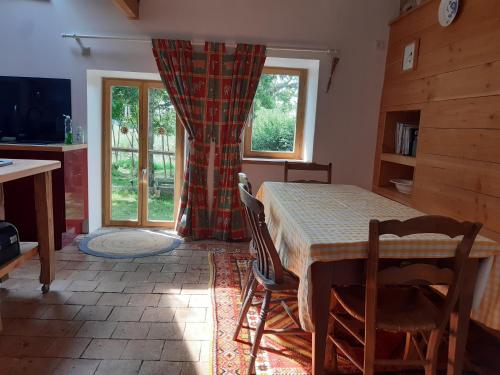 une salle à manger avec une table et des chaises et une fenêtre dans l'établissement Bramble cottage, à Saint-Didier-en-Donjon