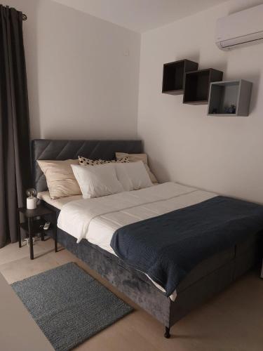 a bed in a white room with a bed frame at Graceful LJUPKA GETAWAY by the sea - Lokva Rogoznica, Omiš in Lokva Rogoznica