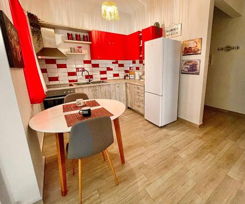 Una pequeña cocina con una mesa y un refrigerador. en VivereFelix - Genius Loci, en Kavala