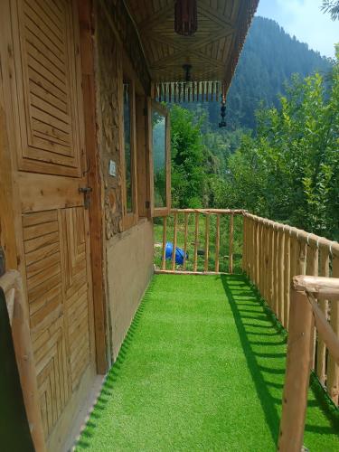 a porch of a house with green grass at विष्णु कॉटेज in Ani