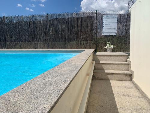 a swimming pool with stairs next to a fence at Casa Carvalhal do Esporão in Lamalonga