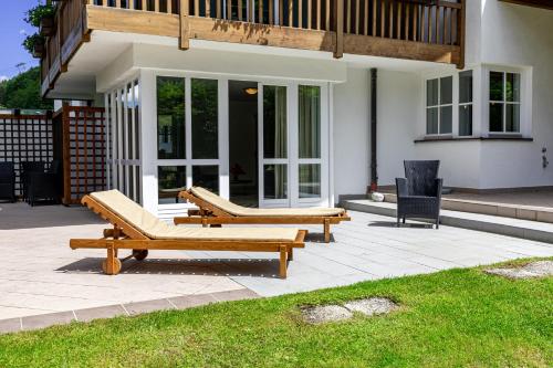 two benches on a patio in front of a house at Chalet Hammersbach in Grainau