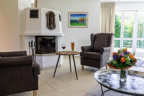 a living room with two chairs and a fireplace at Chalet Hammersbach in Grainau