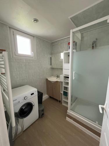 une petite cuisine avec une machine à laver et un évier dans l'établissement Très belle Maison Familiale à 800m de la plage, à Loctudy