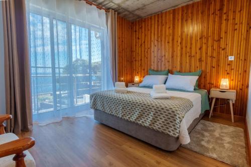 a bedroom with a bed and a large window at Mar Vista Home in Ponta Delgada