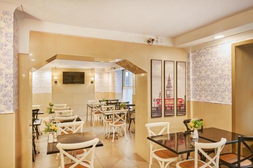 a restaurant with tables and chairs in a room at Huttons Hotel, Victoria London in London