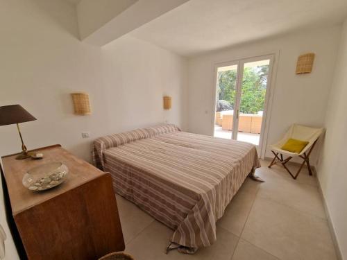 une chambre avec un lit, une table et une fenêtre dans l'établissement Santa Giulia Superbe Villa 8 personnes 150m plage, à Porto-Vecchio