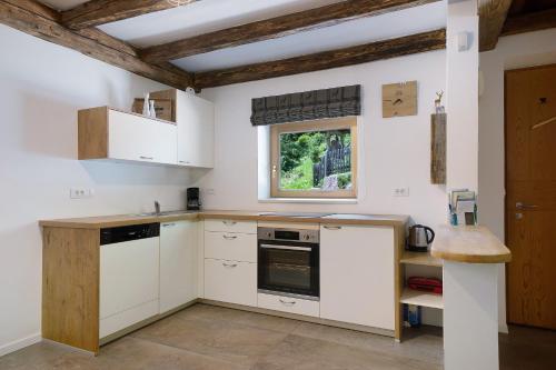a kitchen with white cabinets and a window at Unterurbanhof Apt Die Eins in Unsere Liebe Frau im Walde