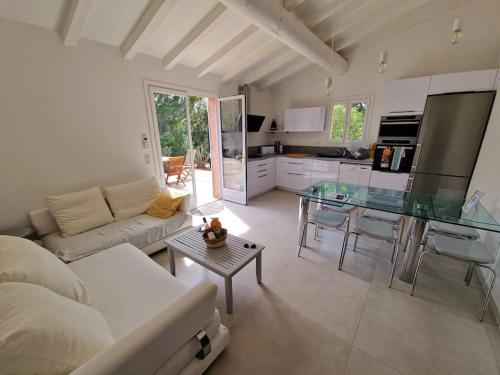 un salon avec un canapé et une table en verre dans l'établissement Santa Giulia Superbe Villa 8 personnes 150m plage, à Porto-Vecchio