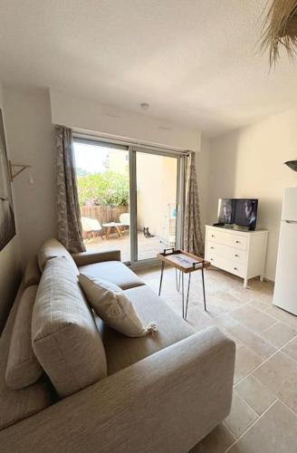 un salon avec un canapé et une grande fenêtre dans l'établissement Studio centre ville- Grand balcon-Meublé BoConcept, à Cavalaire-sur-Mer