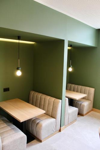 two tables and chairs in a waiting room with green walls at Mondragon Hotela in Arrasate - Mondragon