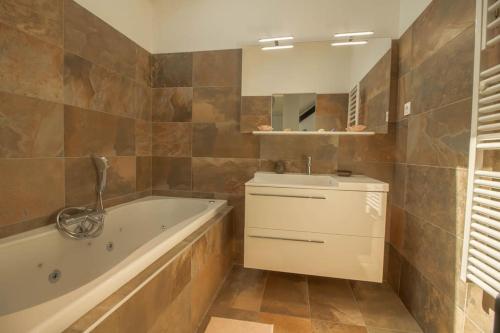 une salle de bain avec une baignoire et un lavabo dans l'établissement VILLA NIKITA Plage, à Andernos-les-Bains