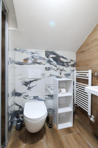 a bathroom with a white toilet and a sink at APARTMÁNY Sninský dvor in Snina