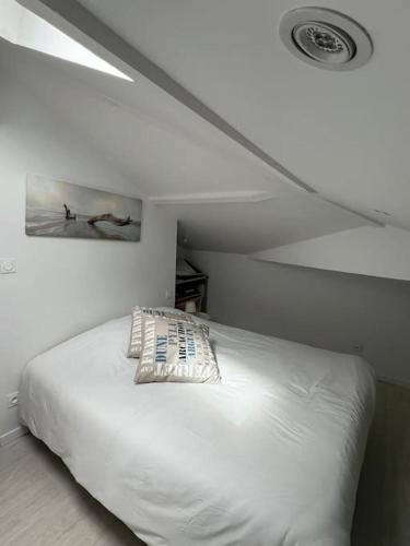 - un lit blanc dans une chambre avec plafond dans l'établissement VILLA NIKITA Plage, à Andernos-les-Bains