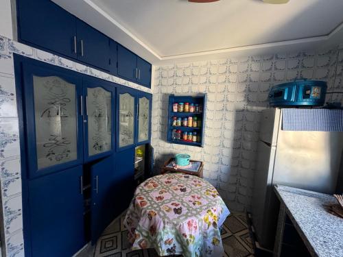 ein blaues Zimmer mit einem Tisch und einer blauen Tür in der Unterkunft Maison oudelaou in Oued Laou