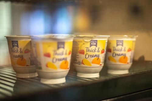 a group of four cups of orange yogurt on a shelf at Crianlarich Youth Hostel in Crianlarich