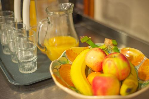 a bowl of fruit on a counter with a glass of orange juice at Crianlarich Youth Hostel in Crianlarich