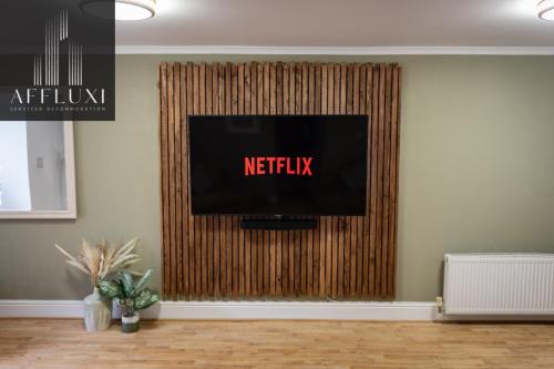 a tv on a wall with a netflix sign on it at Relaxing Ironbridge Hot Tub Retreat in Ironbridge